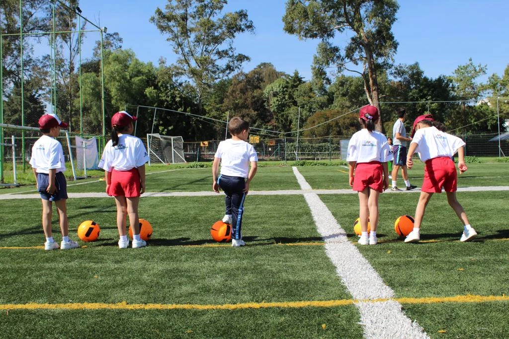 Alumnos de primaria haciendo juegos cooperativos al aire libre